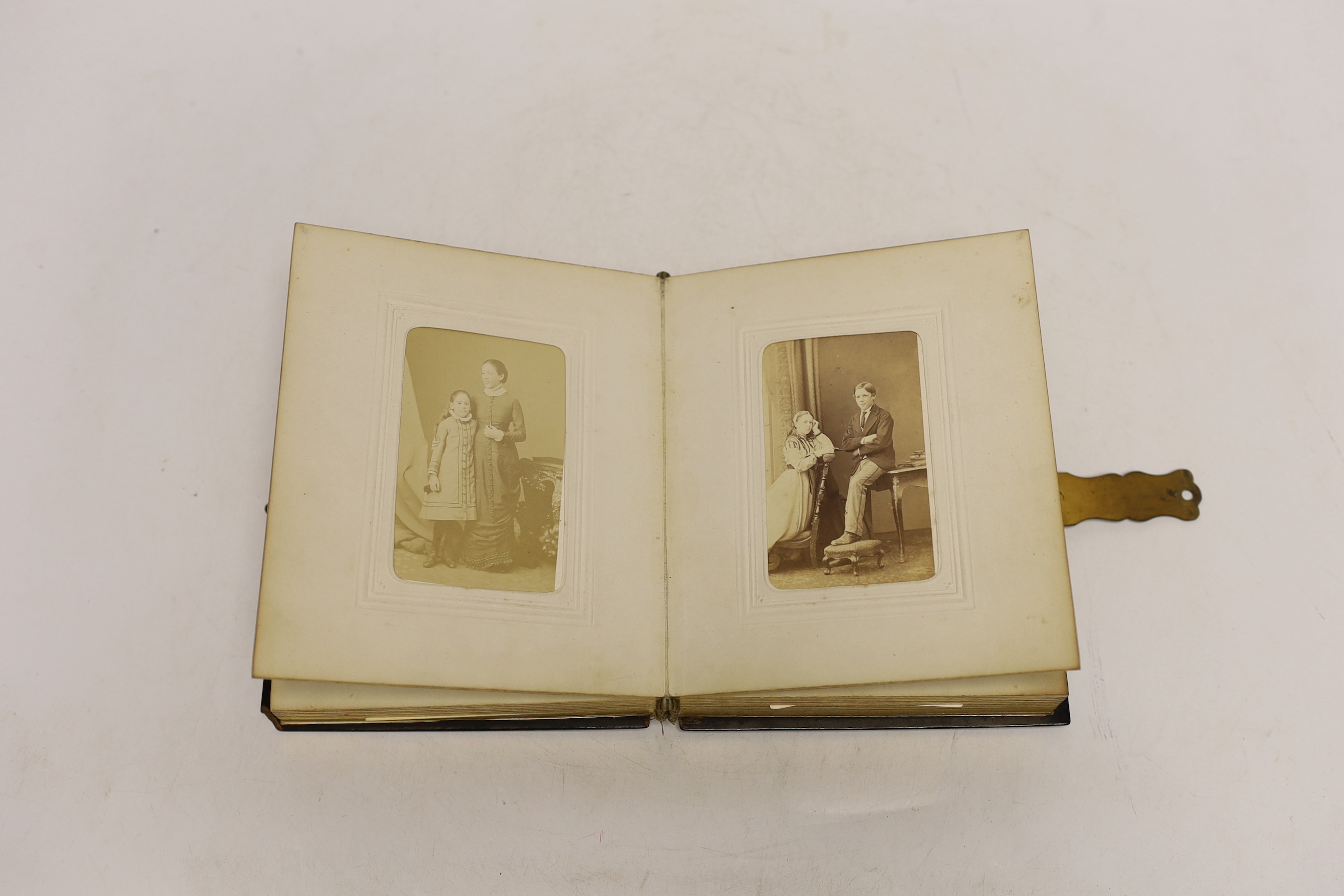 A Russian lacquer boarded photograph album, Lukutin, late 19th century, decorated with a couple and child, containing Victorian photographs, 16 cm x 13.5cm, Please note this lot attracts an additional import tax of 5% on